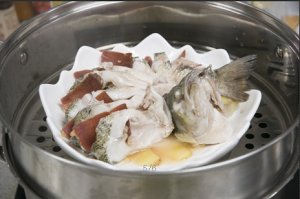 將鱸魚成花狀擺好，將火腿切片放入各縫隙中，放入鍋中隔水蒸12分鐘拿出，撒上蔥花即可。