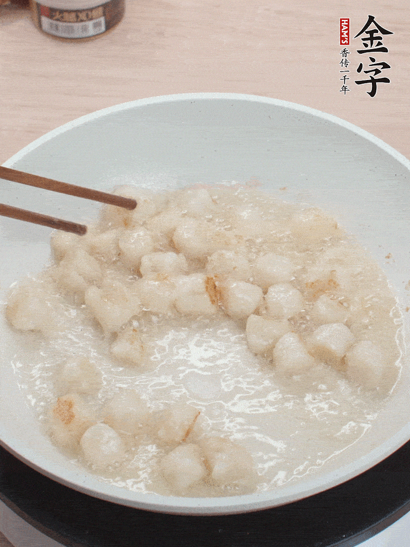 油溫4成熱，鮮貝蘸干淀粉下鍋煎，一面微黃后翻面。