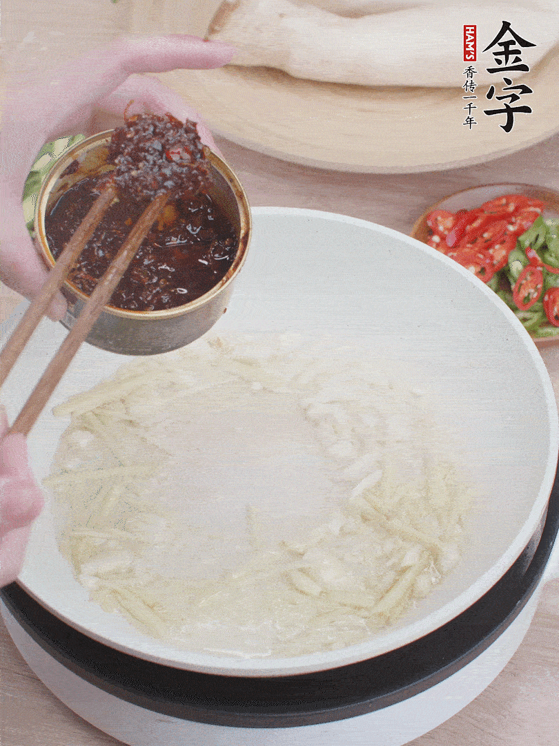起鍋熱油，姜蒜、金字火腿干貝醬煸香。