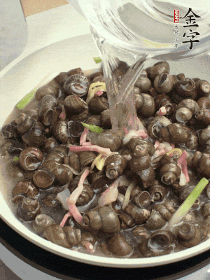 倒處理干凈的螺螄翻炒，加3勺料酒。加清水蓋過螺螄，中火蓋蓋煮5分鐘。