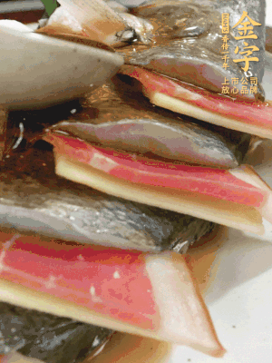 魚肚中塞蔥結(jié)、火腿片，魚身上碼放姜片、火腿片，倒入混合的料汁。